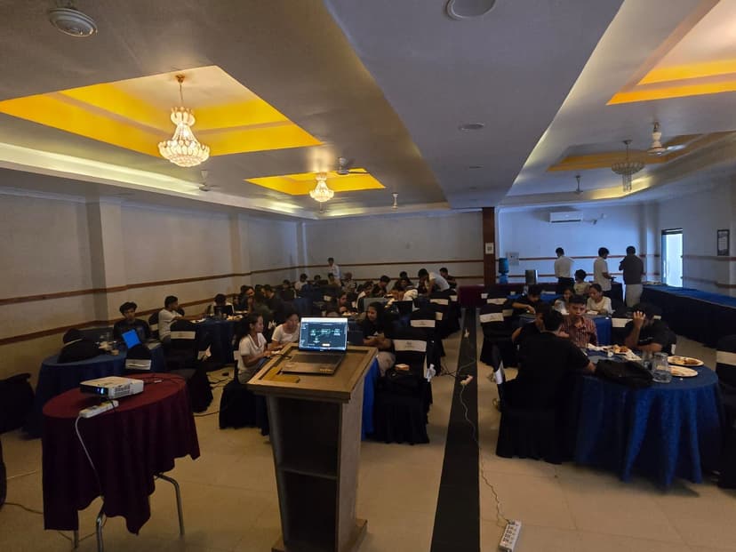 Attendees seated at tables building their first n8n workflow